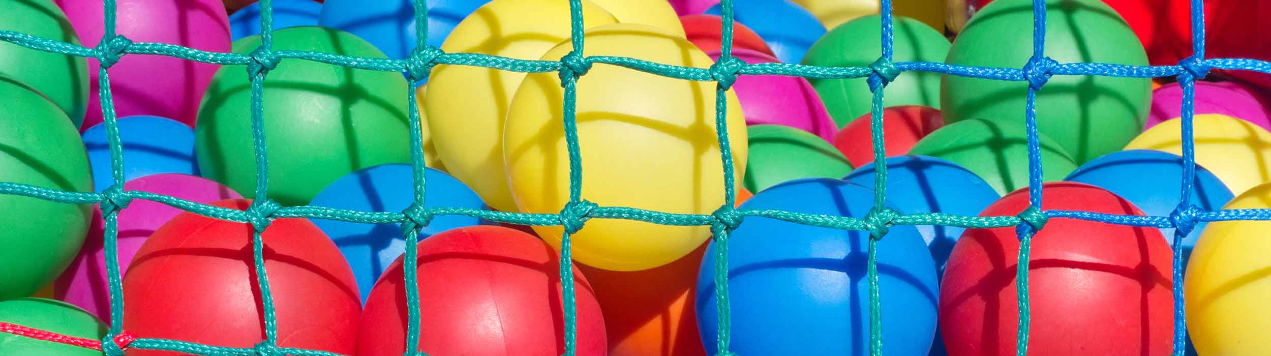 A bunch of different colored balls sitting in a container